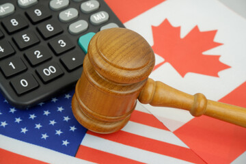Import tariffs of United States and Canada. US and Canadian flags under judge gavel and calculator.