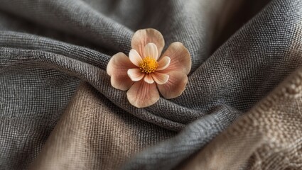 Elegant fabric texture with soft folds and a delicate flower accentuating the natural beauty and subtle colors of the textiles.