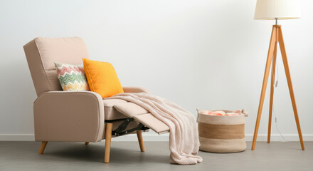 A tan chair with a yellow pillow and a brown basket next to it