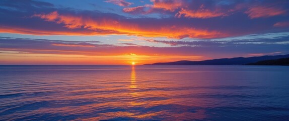 Vibrant coastal sunset with colorful sky reflections over tranquil waters creating a stunning vista and ample space for text overlay.