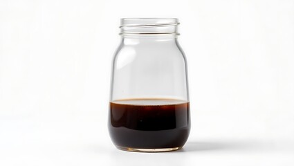 Glass jar filled with dark liquid against a plain background