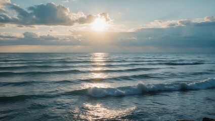 Serene Seascape with Gentle Waves and Sun Breaking Through Clouds Over Calm Waters