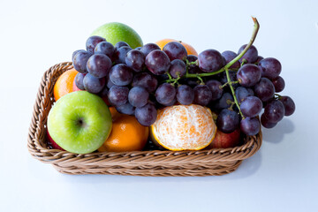 ssorted fresh fruits apple,orange,l in a square basket on white background, with copy space..