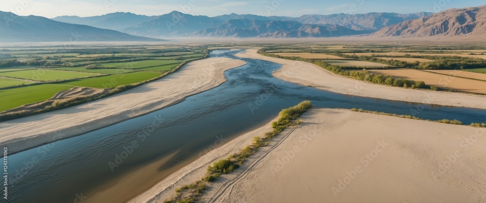 Poster aerial landscape of sandy river and lush fields with mountain range in background and expansive copy