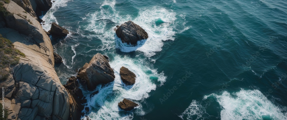 Poster aerial view of rocky coastline with waves crashing into rocks and open space for text overhead ocean