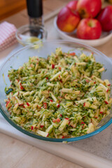 Apple Zucchini salad marinated with apple vinegar, honey and olive oil in a glass bowl