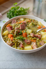 Delicious pea soup with pork meat and vegetables fresh and homemade cooked on a plate