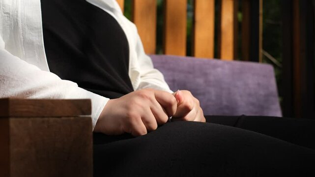 a woman squeezes a napkin from nerves and worries, close-up of her hands