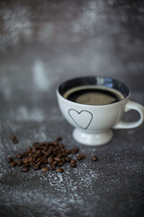 coffee cup on the table with coffee beans next to it