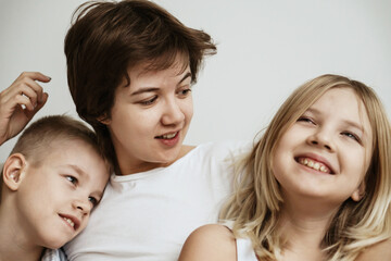 A loving mother with her son and daughter enjoys the magical atmosphere of Christmas and New Year. The family shares joyful moments, playing together, laughing, and creating warm holiday memories