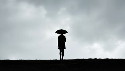 Silhouette of person holding umbrella against overcast sky, solitude