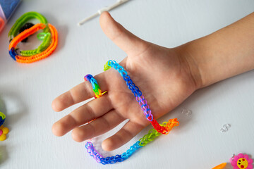 Child's Hand Showcasing Colorful Loom Band Bracelets on White Background