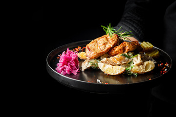 A beautifully presented plate featuring roasted chicken, garnished with fresh herbs, served...