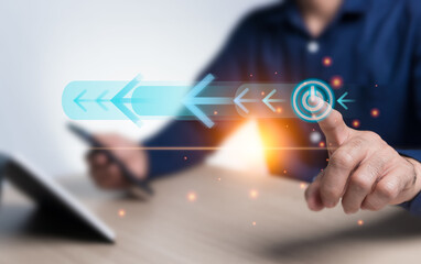 On off button, switch, and arrow virtual hologram icon drive the operation of the cutting-edge technology system and add orange light to the image. The businessman points to the start button.