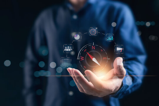 Compass for navigation, direction of business strategy to achieve the highest goal,  of personnel control, scheduling and public relations, businessman set the compass to guide to success. Dark tone