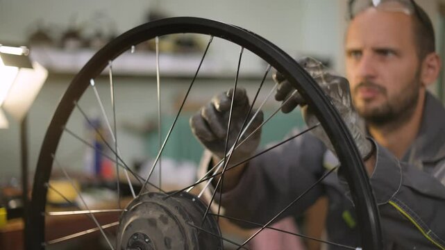 A bicycle master repairs and balances a bicycle wheel. Bicycle service.