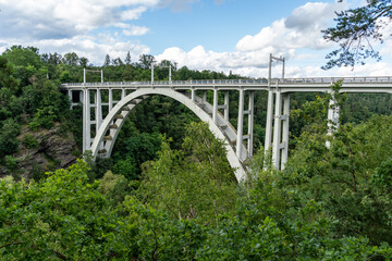Railway and road arched bridge over a deep valley between two hills in the town of Bechyně. Bridge...