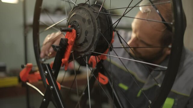 A bicycle master repairs and balances a bicycle wheel. Bicycle service.