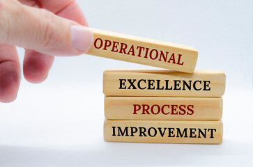 Operational Excellence and Process Improvement text on wooden blocks with small ladder background. Business concept