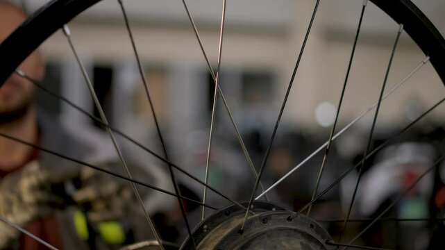 A bicycle master repairs and balances a bicycle wheel. Bicycle service.
