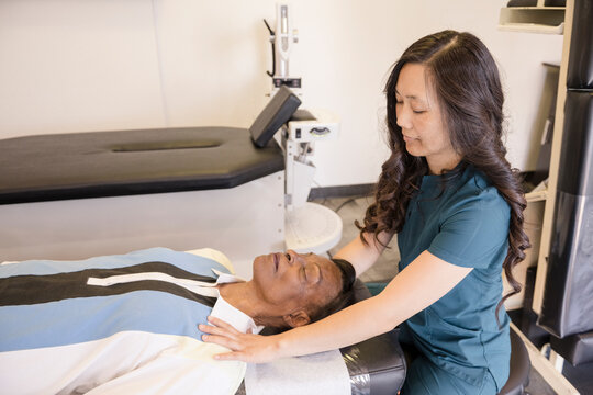 Patient laying down while doctor evaluates shoulder