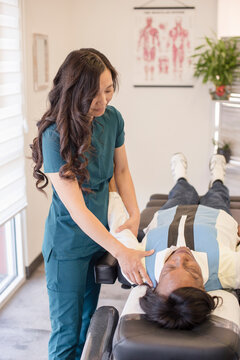 Doctor evaluating patients shoulder while laying down