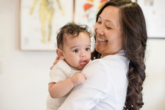 Doctor smiling at baby on shoulder