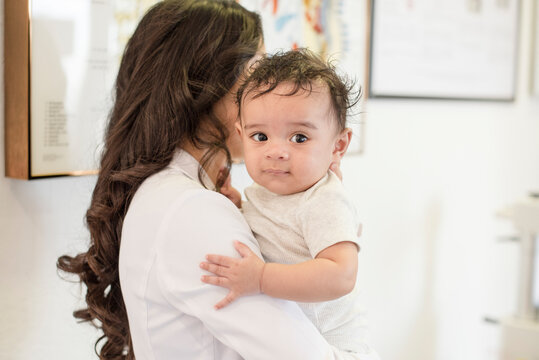 Baby looking over shoulder of doctor