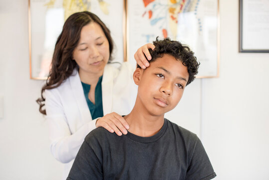 Doctor looking at young patients neck