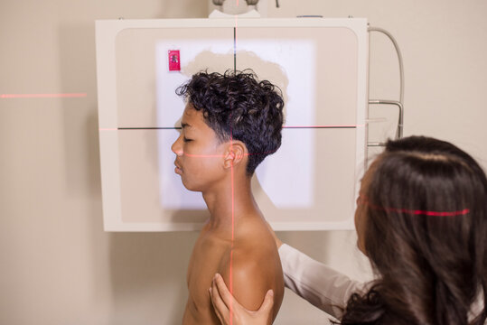 Young boy being positioned for an x-ray by doctor