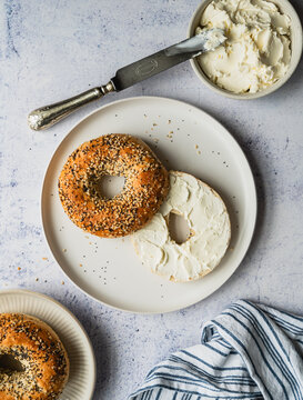 Top view of everything bagel with cream cheese on plate.