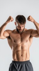 Fototapeta premium Strong male athlete flexing muscles confidently on white background showcasing physical strength and fitness