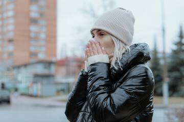 A beautiful young woman walks through a snowy city on a winter day, joyfully chatting on her phone. She smiles and laughs, radiating warmth and happiness. The clip captures a cozy lifestyle vibe