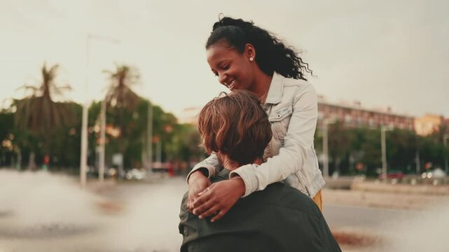 Close-up, man and woman hugs and walk on urban city background. Closeup, happy interracial couple walking hugging. Camera moves around the people