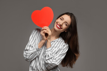 Happy Valentine's Day. Beautiful woman with paper heart on grey background