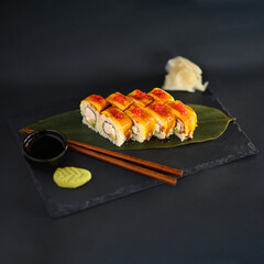 A selection of fresh sushi served on a plate, showcasing an assortment of rolls with vibrant colors and textures. The dish is perfect for an Asian restaurant menu, highlighting traditional flavors.