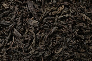 Pile of dry tea leaves as background, top view