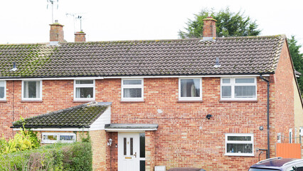 A view of English residential rooftops in an overcast suburban district.