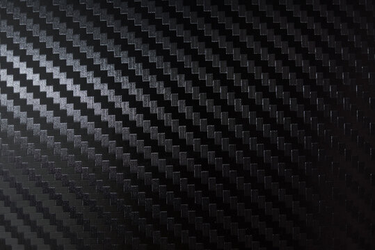 Carbon fiber composite raw material background. Carbon fiber texture. Dark Gray background with lighting.
