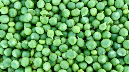 A plate filled with a generous amount of fresh peas, showcasing their vibrant green color and natural appeal, ready to be used in a delicious dish.