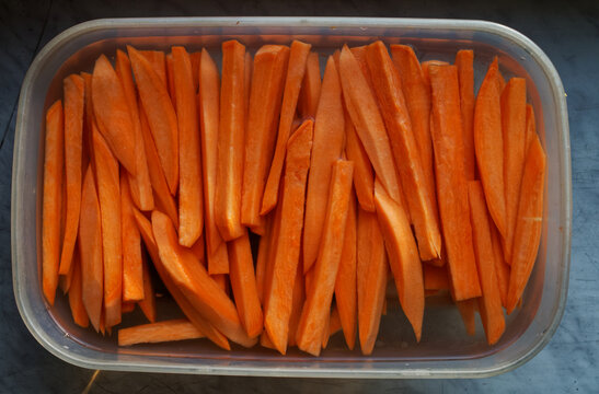 Pokrojone bataty (na frytki) w pudełku wypełnionym wodą