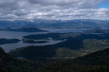 Patagonian landscape. View of the hills, Nahuel Huapi lake, and forest under a magical sky with clouds, seen from the top of Cerro Lopez in Bariloche