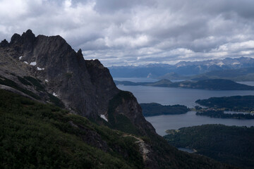 Fototapeta premium Patagonian landscape. Panorama view of the rocky mountains, forest and Nahuel Huapi lake under a cloudy sky, seen from high in Cerro Lopez