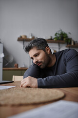 Obraz premium Handsome man in a modern kitchen thoughtfully examining documents during a quiet afternoon