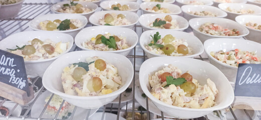 Deliciously arranged bowls of fresh salad with grapes in a bright market setting