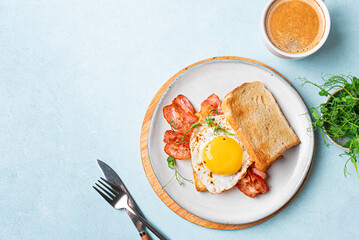 Breakfast toast with fried egg, bacon and microgreens