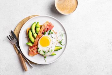 Toasted sandwich with fried egg, bacon, avocado
