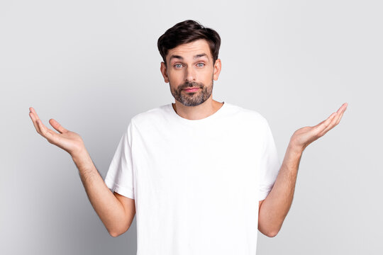 Stylish Young Man in Casual White T-Shirt Expressing Confusion with Hands in a Minimalistic Neutral Background