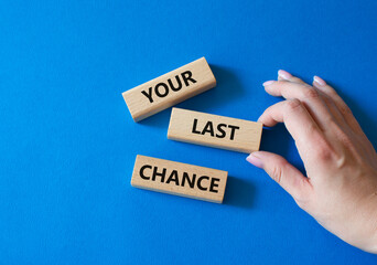 Your last Chance symbol. Concept words Your last Chance on wooden blocks. Businessman hand. Beautiful blue background. Business and Your last Chance concept. Copy space.