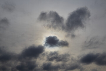 Gray clouds covering the sun in the sky, rain clouds signaling a weather change, sky with gray clouds, clusters of gray clouds, weather transition.